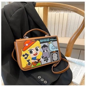 Détail d'un sac bandoulière marron vintage avec broderie street art et patch fille dessin