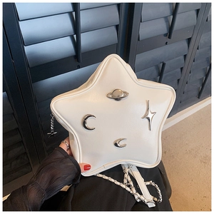 Detail of star-shaped white leather bag with metallic celestial charms and chain strap