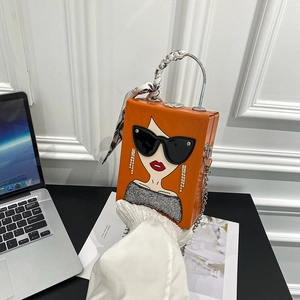 Detail of orange box handbag featuring pop art woman illustration and silk scarf handle
