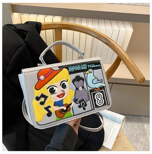 Détail du sac bandoulière gris avec broderie pop art colorée de style mexicain sur chaise