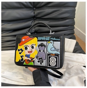 Détail du sac à bandoulière noir avec broderies cartoon et texte Street Art Milano