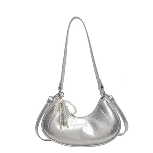 Silver metallic crescent underarm bag with pearl bow and heart pendant detail