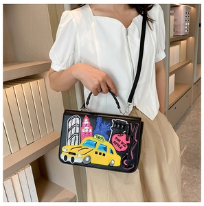 Detail of black crossbody bag featuring colorful New York themed embroidery and patches