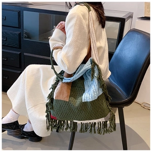 Detail of colorful knitted shoulder bag with fringe tassel and geometric block pattern