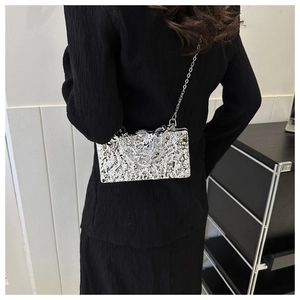 Detail der silbernen Acryl-Box-Tasche mit Eisrissen und eleganter Metallkette