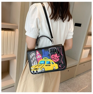 Detail of a vintage-style black structured handbag with colorful NYC city patches
