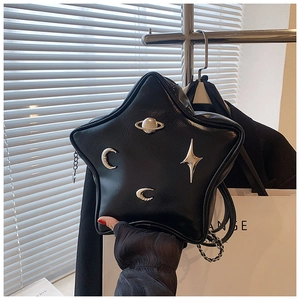 Detail shot of a black star-shaped crossbody bag with Saturn and moon metallic ornaments