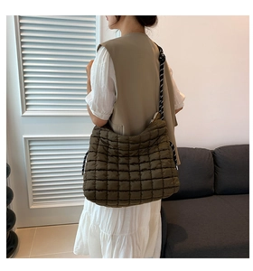 Sac fourre-tout matelassé vert olive avec bandoulière tissée dans un décor de maison