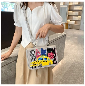 Detailed embroidery of NYC yellow taxi and Statue of Liberty on a gray shoulder bag