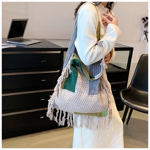 Detail of knit tote bag with color blocking and decorative long fringe on the side