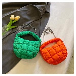 Primer plano de bolsos acolchados en naranja y verde con cadenas de color plata