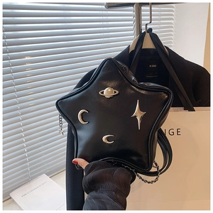 Detail of star-shaped black PU leather bag with silver cosmic metal charms and chain