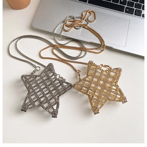Detailed view of mini star-shaped hollow metal handbags in gold and silver with chain straps