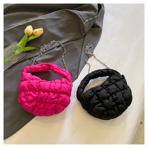 Detalle de bolsos acolchados tipo nube en fucsia y negro con correas de cadena plata