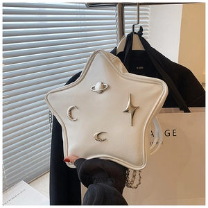 Detail of star-shaped white leather handbag with silver planet and moon metal accents