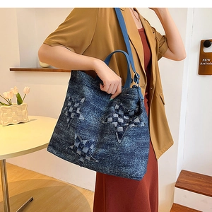 Detail view of denim tote bag with star embroidery and adjustable shoulder strap