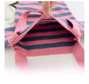 Detailed view of internal opening structure on pink and blue striped knitted tote bag