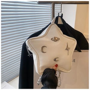 Detail of white star-shaped PU leather bag with silver celestial moon and planet ornaments