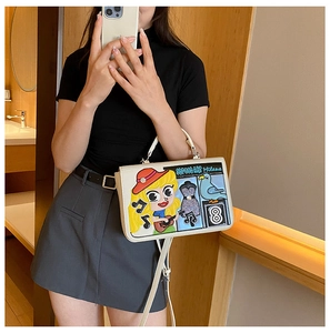 Selfie miroir montrant un sac bandoulière blanc avec des broderies de dessins animés pop art