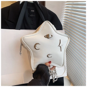 Detail of white star-shaped leather bag with silver planetary charms and chain strap