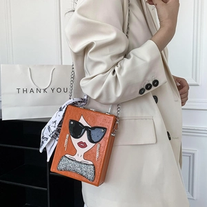 Fashionable orange box bag with girl print, silver chain, and silk scarf crossbody detail