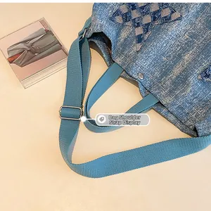 Detail of blue denim tote bag showing star patch and adjustable turquoise shoulder strap