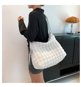 Détail du sac cabas matelassé blanc avec bandoulière à pois et décoration de gland