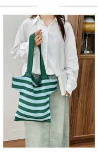 Detail view of a star-shaped striped knit tote bag in green and blue colors