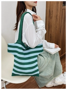 Detail of green and blue striped knit tote bag with unique T-shirt design and wide strap