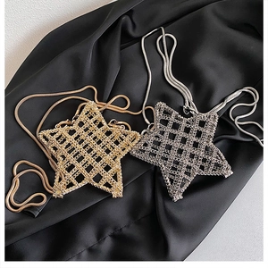 Detail view of mini star-shaped metal mesh bags in polished gold and silver finishes