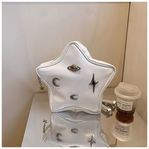 Detail of star-shaped white leather shoulder bag with metal moon and star ornaments