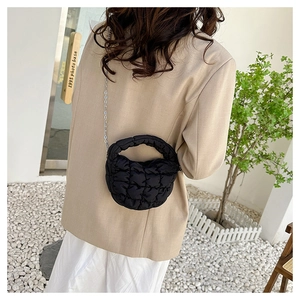 Detalle de bolso nube negro acolchado con textura suave y cadena de plata
