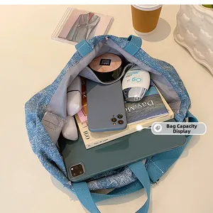 Detail view of large denim tote bag showing spacious capacity for tablet and daily items