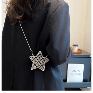 Chic silver star-shaped hollow mesh crossbody bag with a delicate chain strap shown on model