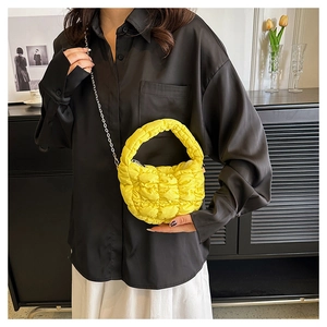 Detalle del bolso de nube acolchado amarillo con textura de plumón y cadena