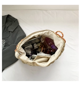 Intérieur spacieux du sac cabas matelassé beige avec une tablette et des cosmétiques