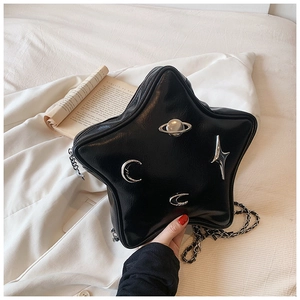Detail of star-shaped black leather shoulder bag with silver planet and moon charms