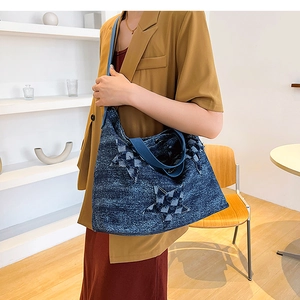 Detail of large denim tote bag featuring a star patchwork design with woven handles