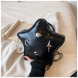 Detail of star-shaped black faux leather bag with silver planetary and crescent charms