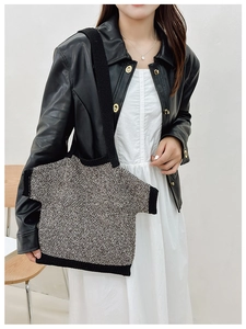 Detail view of a creative T-shirt shaped knit shoulder bag with black ribbed trim accents