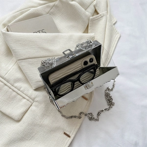 Silver mirror acrylic box bag with metal chain shown with phone and glasses