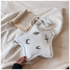 Detail of star shaped white faux leather bag with silver planetary metal decorations