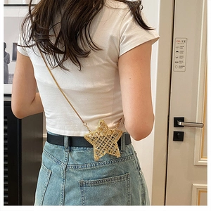 Close-up of a gold star-shaped mini crossbody bag with a metallic mesh chain strap