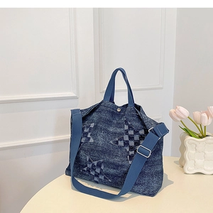 Close-up of blue denim tote bag with star checkered patches on white round table