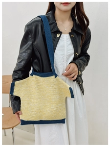 Detail of creative T-shirt shaped knitted shoulder bag in yellow with blue contrast trim