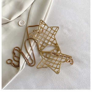 Detail of gold star-shaped hollow charm on a sleek snake chain with textured mesh finish