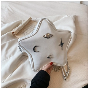 Detail of star-shaped white leather bag with silver planetary metallic ornaments