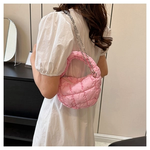 Detalle de bolso acolchado rosa tipo nube con cadena plateada y textura suave