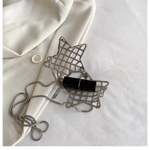 Detailed view of a star-shaped silver mesh mini bag with an elegant snake chain strap