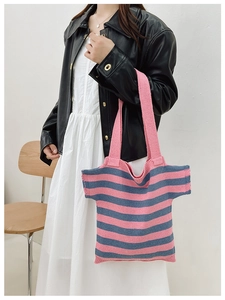 Detail of creative T-shirt shaped striped knit shoulder bag in pink and navy blue